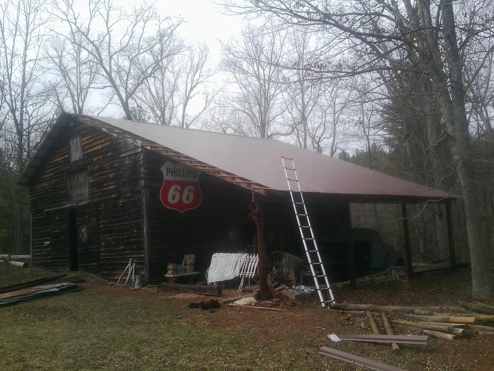 New metal roof on an open sided timber barn with a vintage sign in Talladega