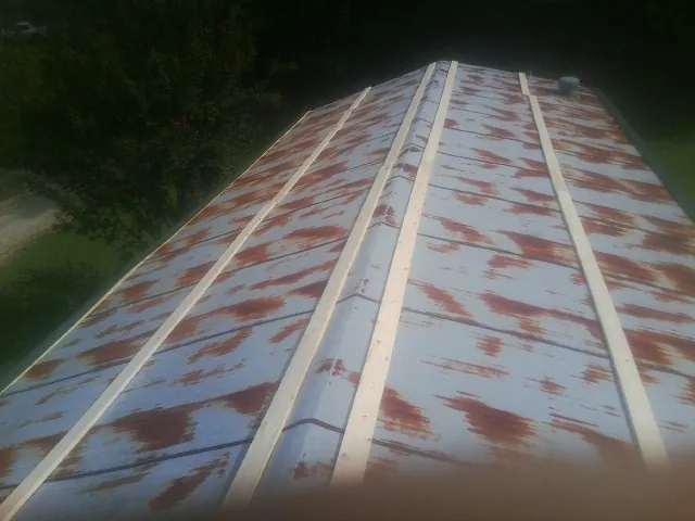 Rusted metal roof panels with new wood purlins before replacement — Storm Damage Roof Repair in Talladega by Roofing Brothers