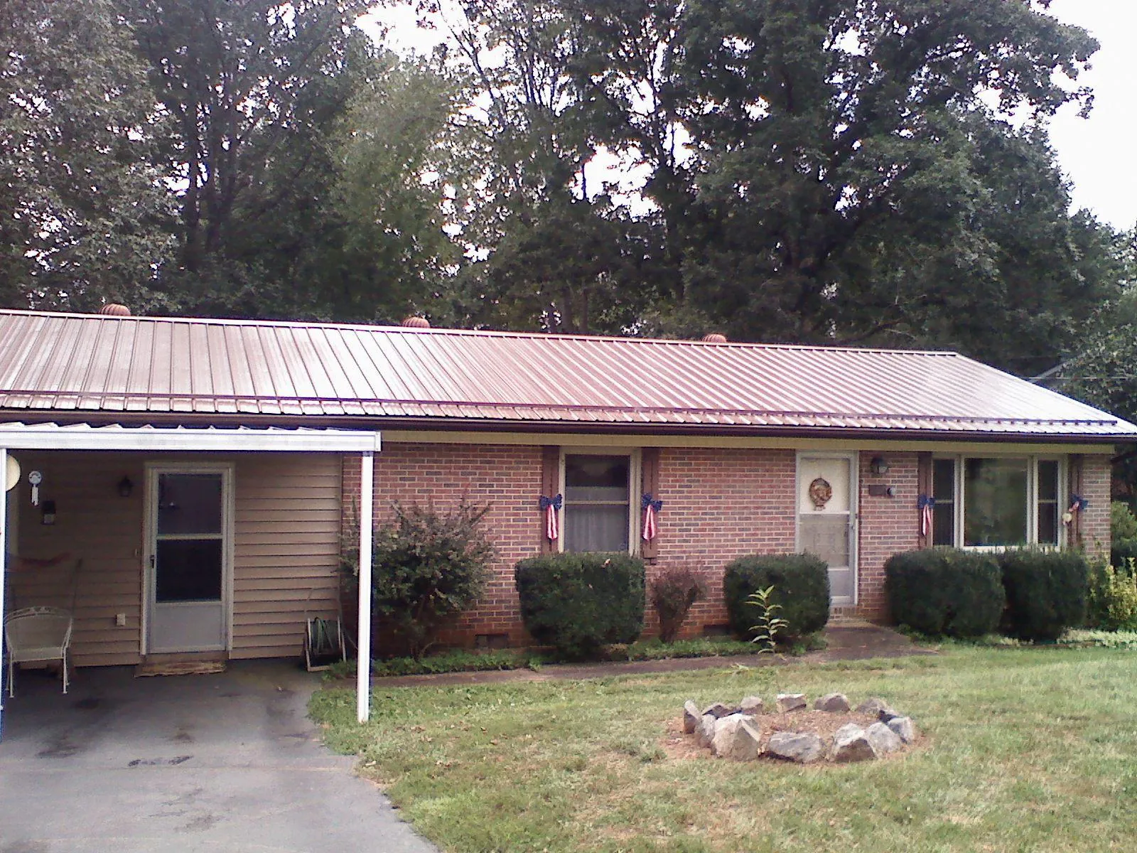 Bronze metal roof and carport on a brick ranch home — Roof Repair work by our crew in Talladega