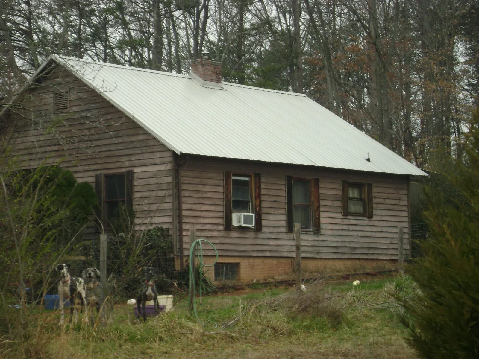 White metal roof on an old wood sided farmhouse, from a Metal Roof Installation job in Talladega